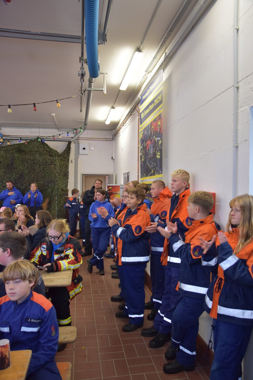 Jugendfeuerwehrmitglieder aplaudieren den Gewinnern des Turniers
